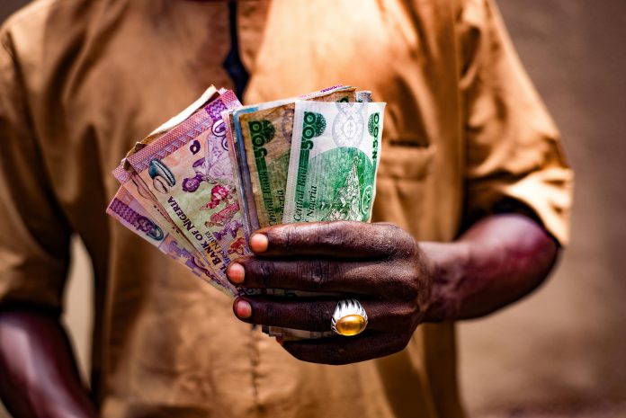 free-photo-of-man-holding-nigerian-currency-in-bida